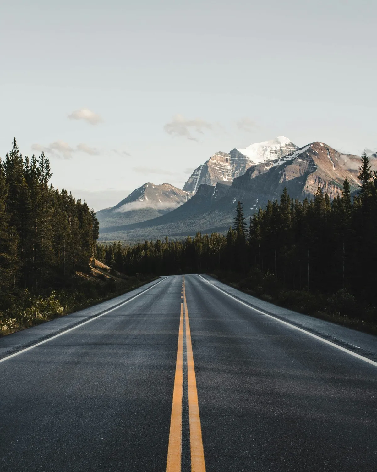 Carretera despejada hacia unas montañas nevadas